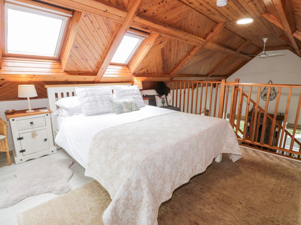 A bedroom with a bed and bedside lamp at The Barn in Rockcliffe