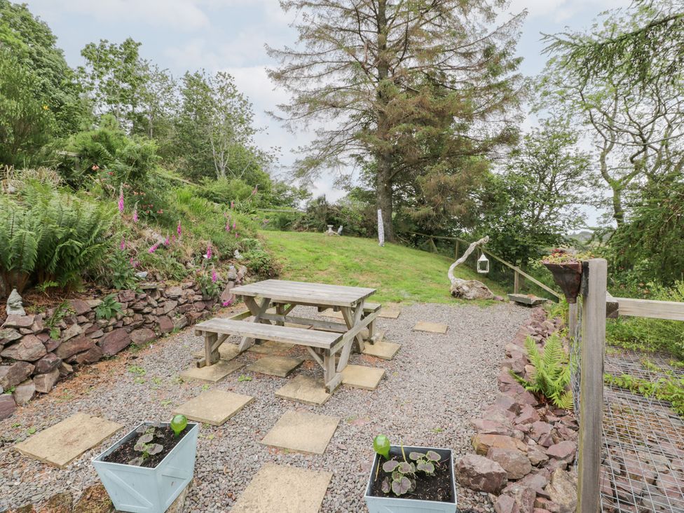 A garden with gravel path, table, and bench at The Barn in Rockcliffe