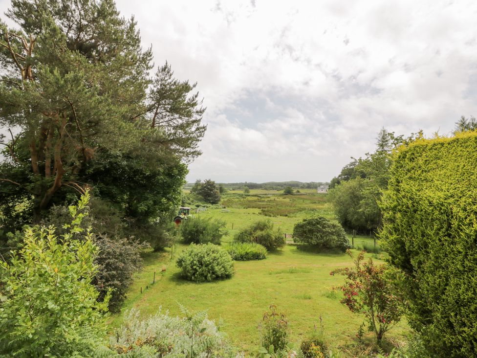 A garden with trees and grass at The Barn in Rockcliffe