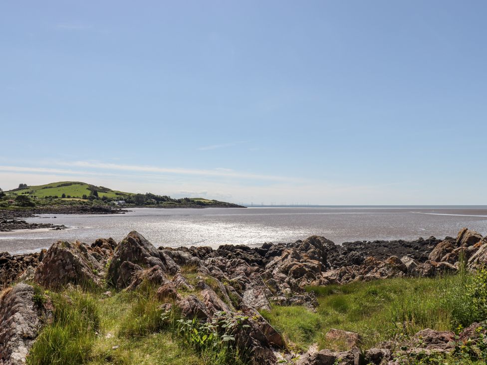 A coastal scene with rocks and grass at The Barn in Rockcliffe