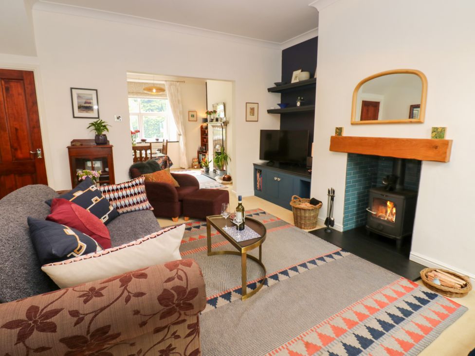 A living room with a sofa, table, and fireplace at 4 Ford Street Lanchester