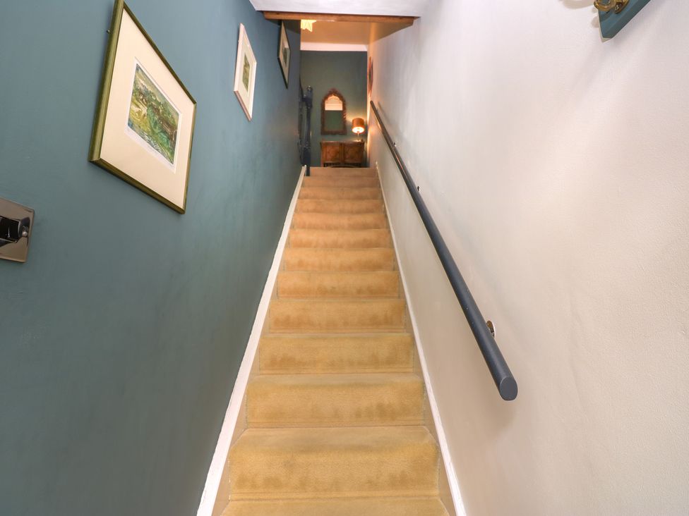 A staircase with paintings on the wall at 4 Ford Street in Lanchester