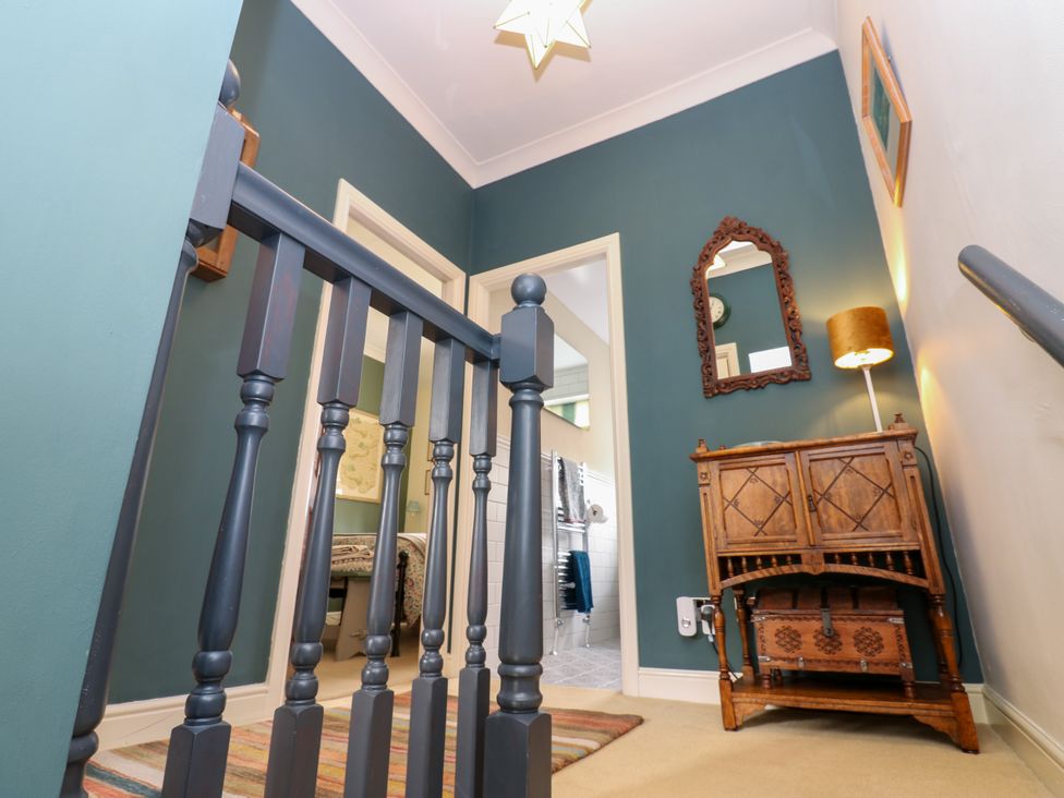 A hallway with a wooden cabinet and mirror at 4 Ford Street Lanchester