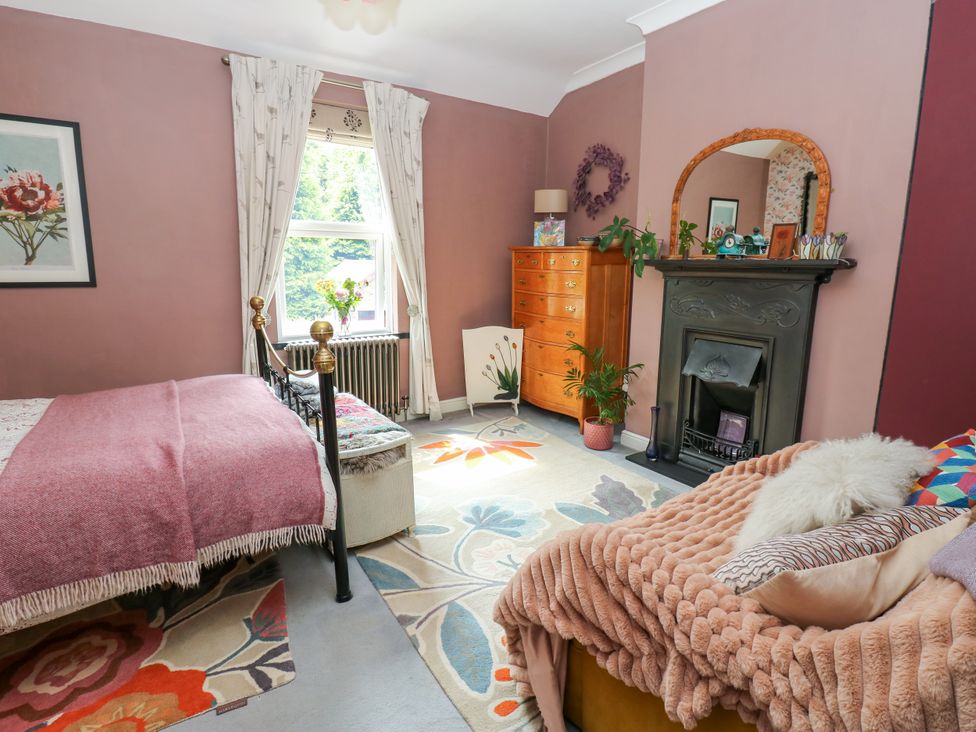 A bedroom with a bed, chest of drawers, and a fireplace at 4 Ford Street, Lanchester