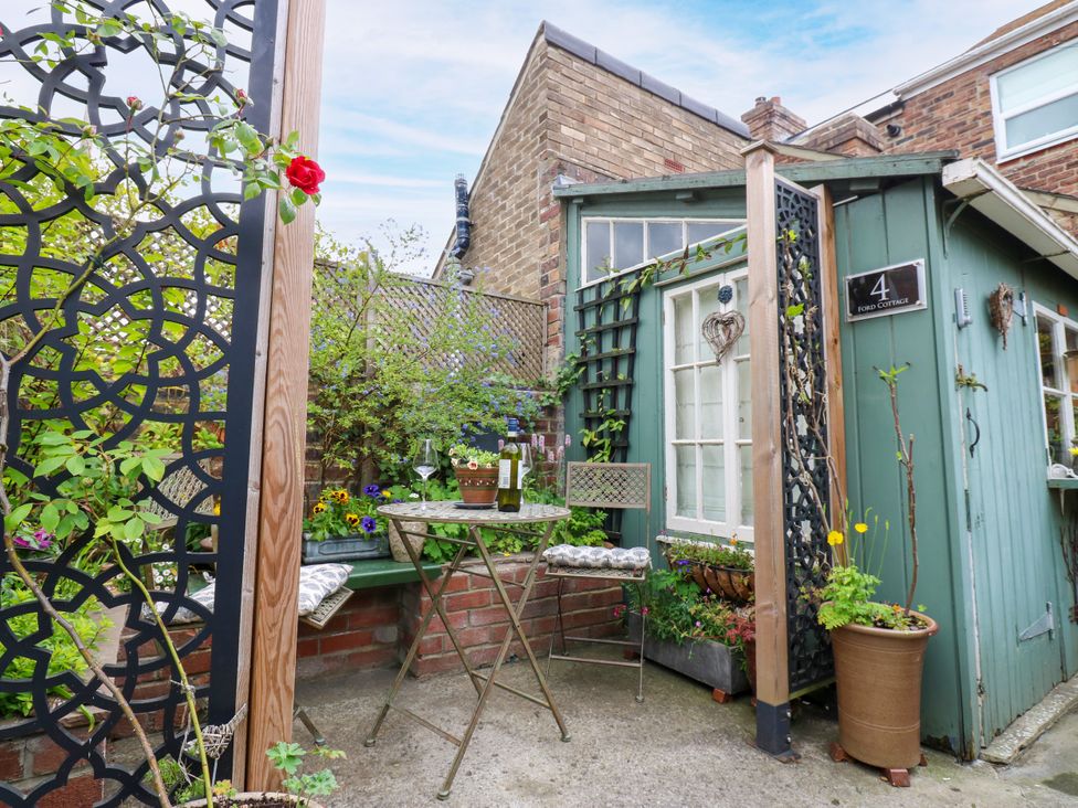 A garden area with a table and chair near a house at 4 Ford Street Lanchester