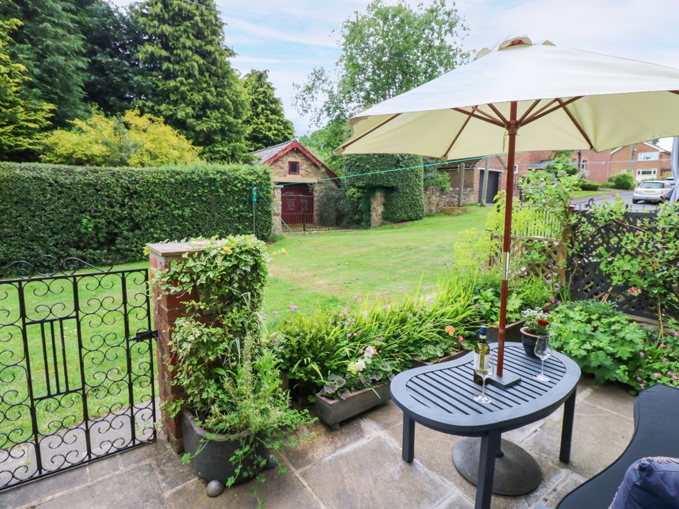 A garden with a table and chairs under an umbrella at 4 Ford Street Lanchester
