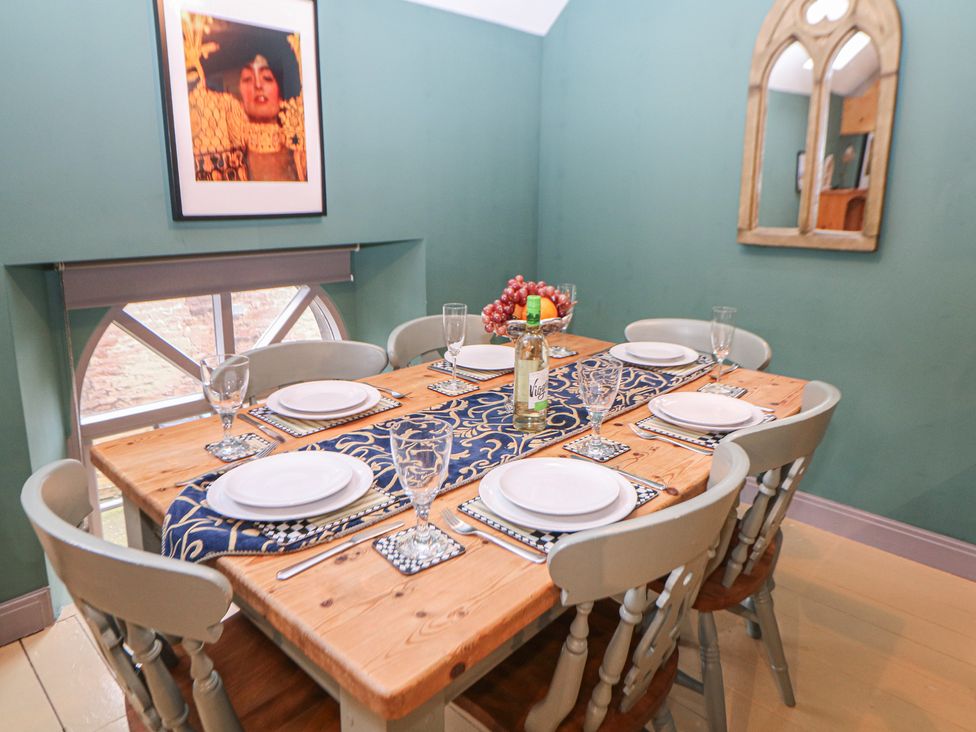 A dining room with a wooden table set for a meal at Nine Ladies in Birchover