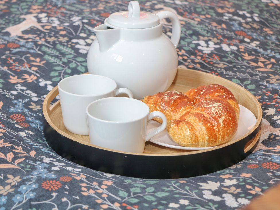 A tray with a teapot, two cups, and a croissant at Nine Ladies in Birchover