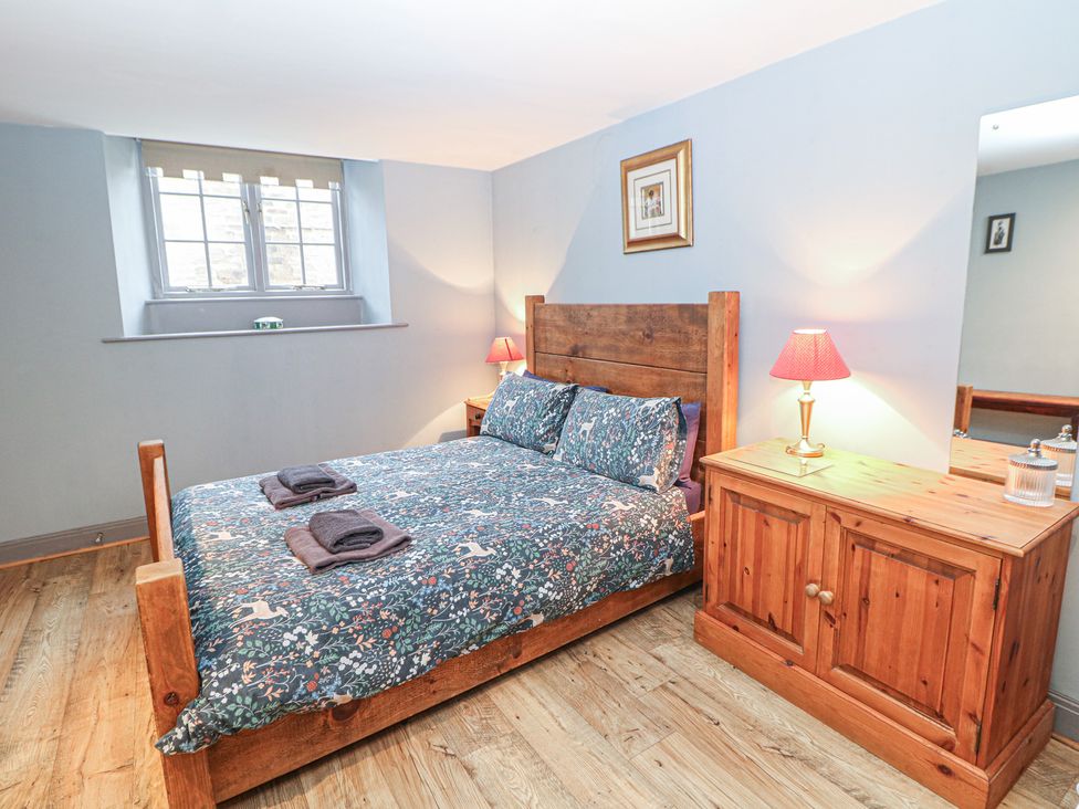 A bedroom with a bed and dresser at Nine Ladies in Birchover