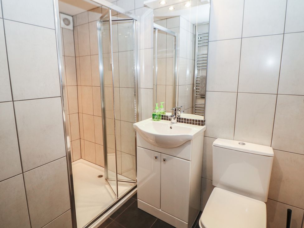 A bathroom featuring a shower, toilet, and sink at Nine Ladies in Birchover
