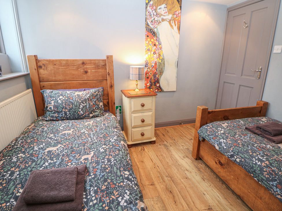 A bedroom with two single beds and a lamp at Nine Ladies in Birchover