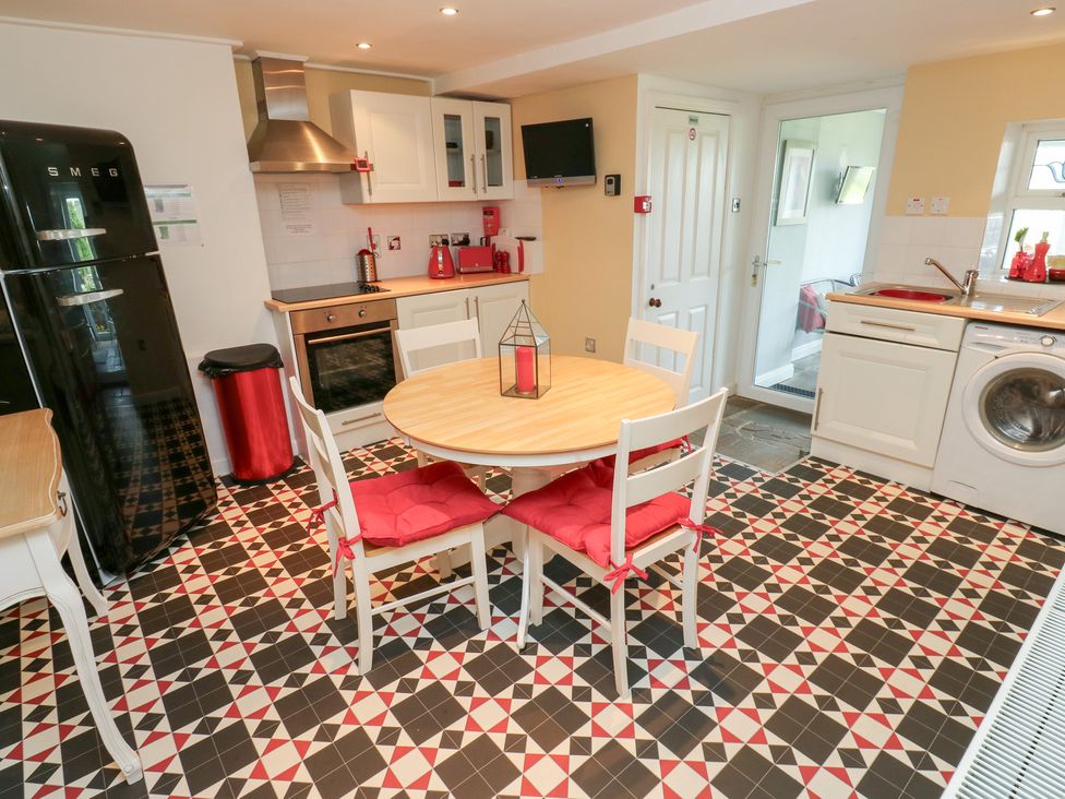 A kitchen with appliances and a dining table at The Thyme House in Haworth
