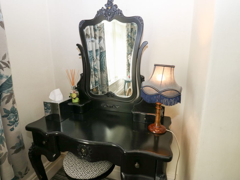 A vanity table with a mirror and lamp at The Thyme House in Haworth