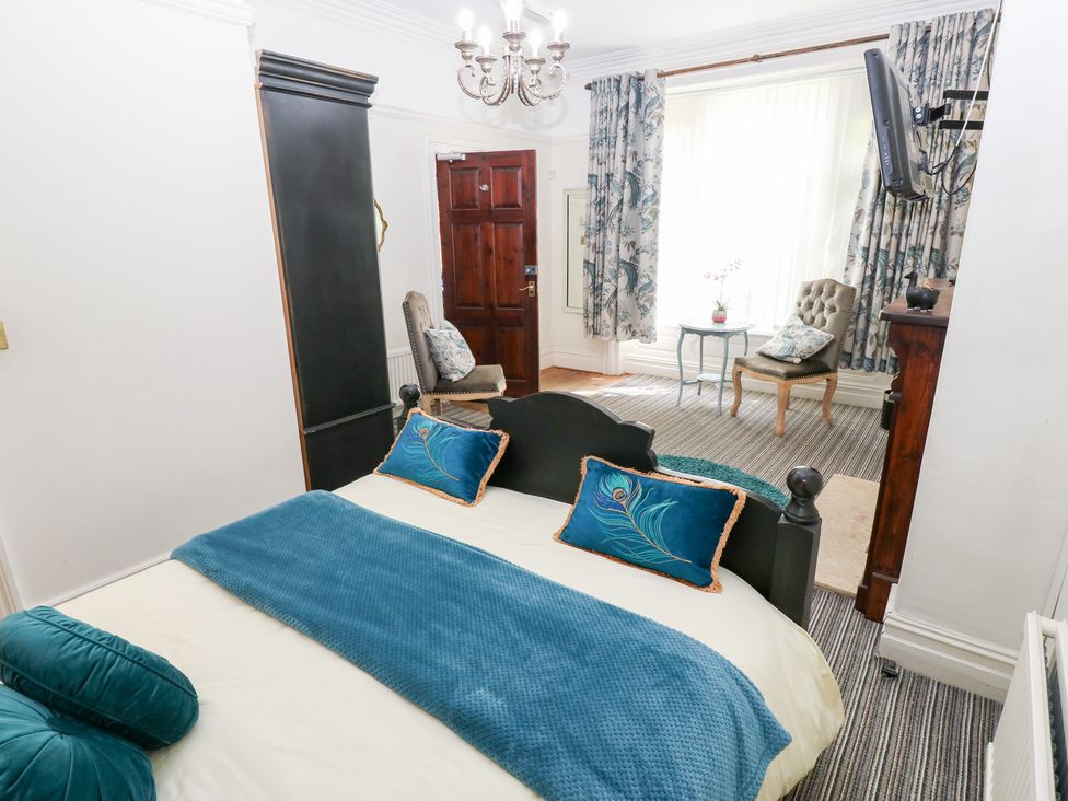A bedroom with a bed and chair at The Thyme House in Haworth