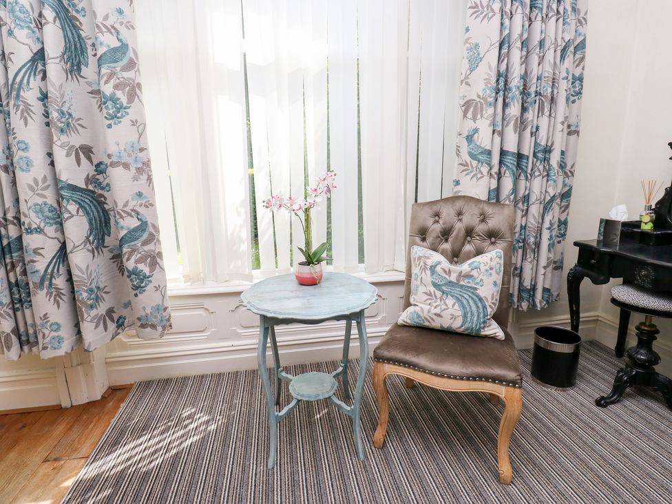 A sitting room with a chair and table at The Thyme House in Haworth