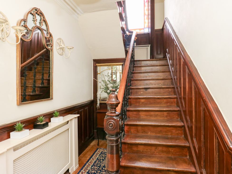 A staircase with a mirror and radiator in the hallway at The Thyme House in Haworth