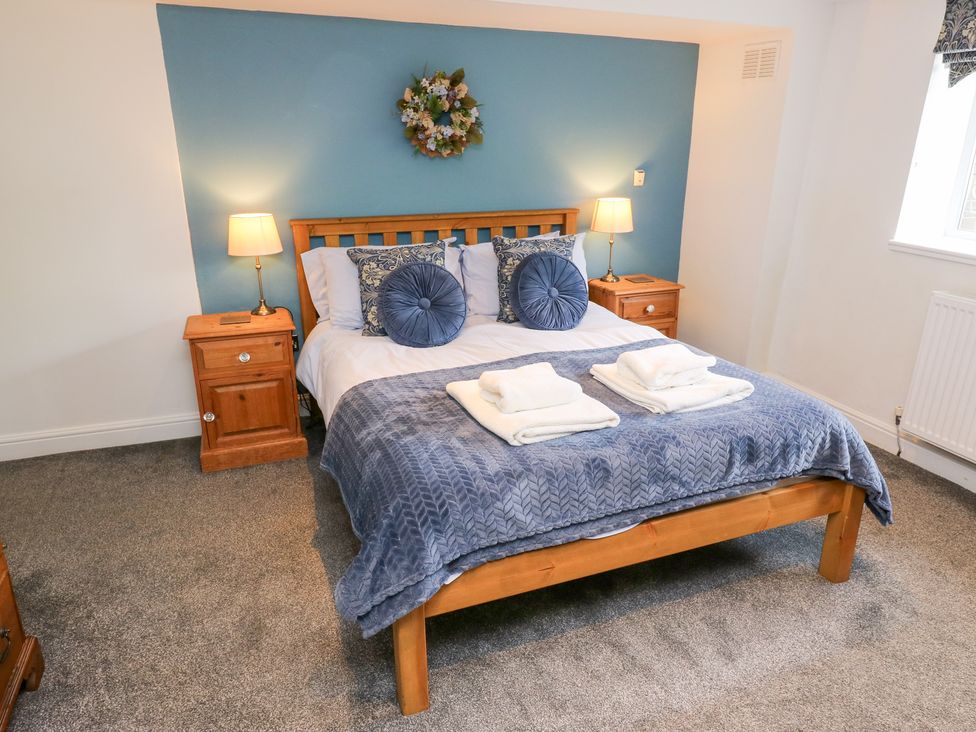 A bedroom with a bed and bedside tables at The Thyme House in Haworth