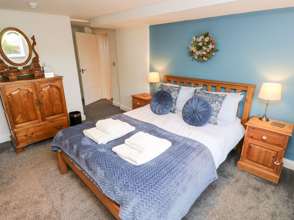 A bedroom with a bed and wooden furniture at The Thyme House in Haworth