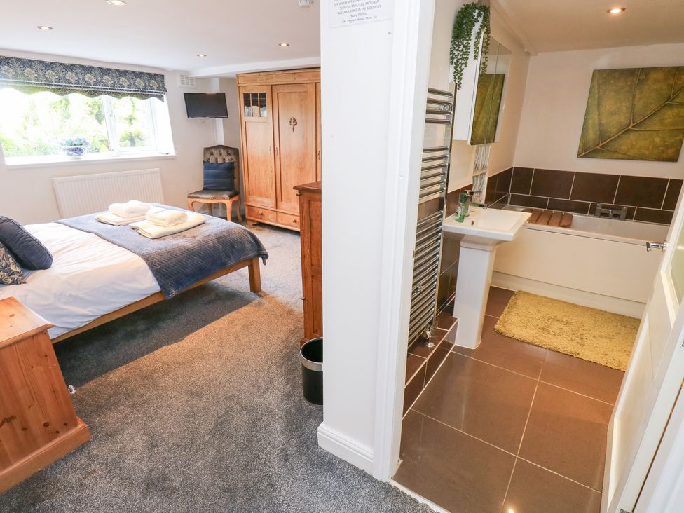 A bedroom with a bed and adjoining bathroom at The Thyme House in Haworth