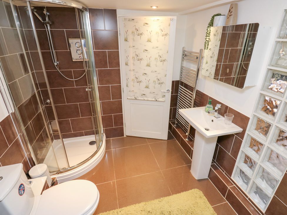 A bathroom with a shower, toilet, and sink at The Thyme House in Haworth