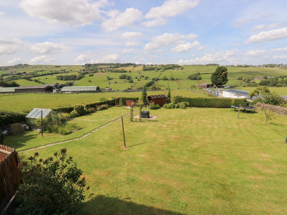 A garden with grass and outdoor structures at The Thyme House in Haworth