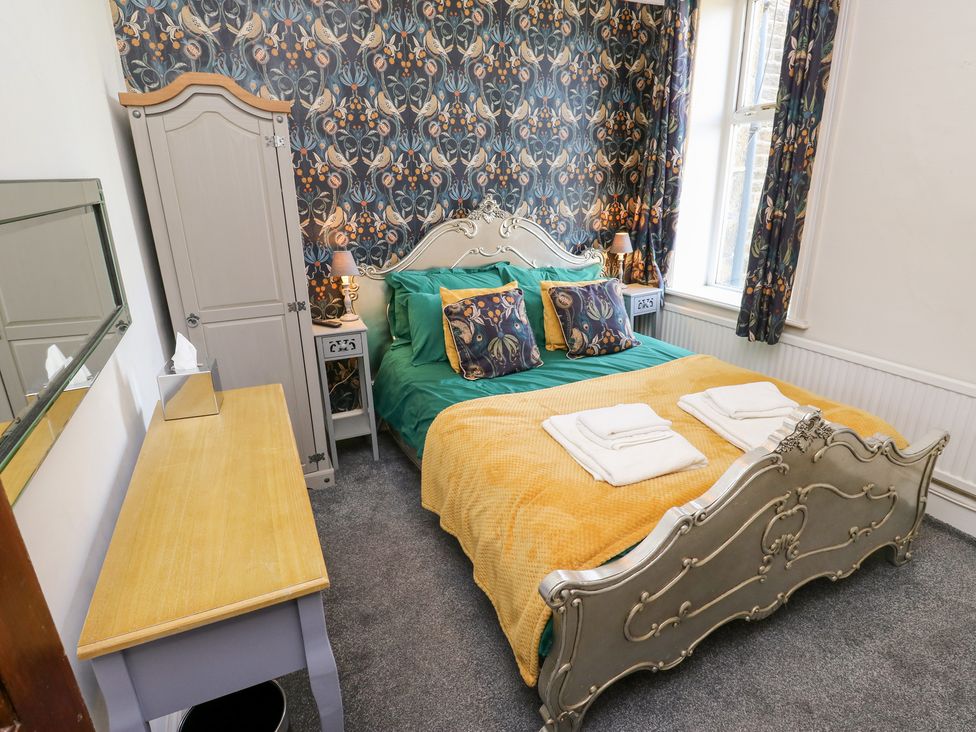 A bedroom with a bed and wardrobe at The Thyme House in Haworth