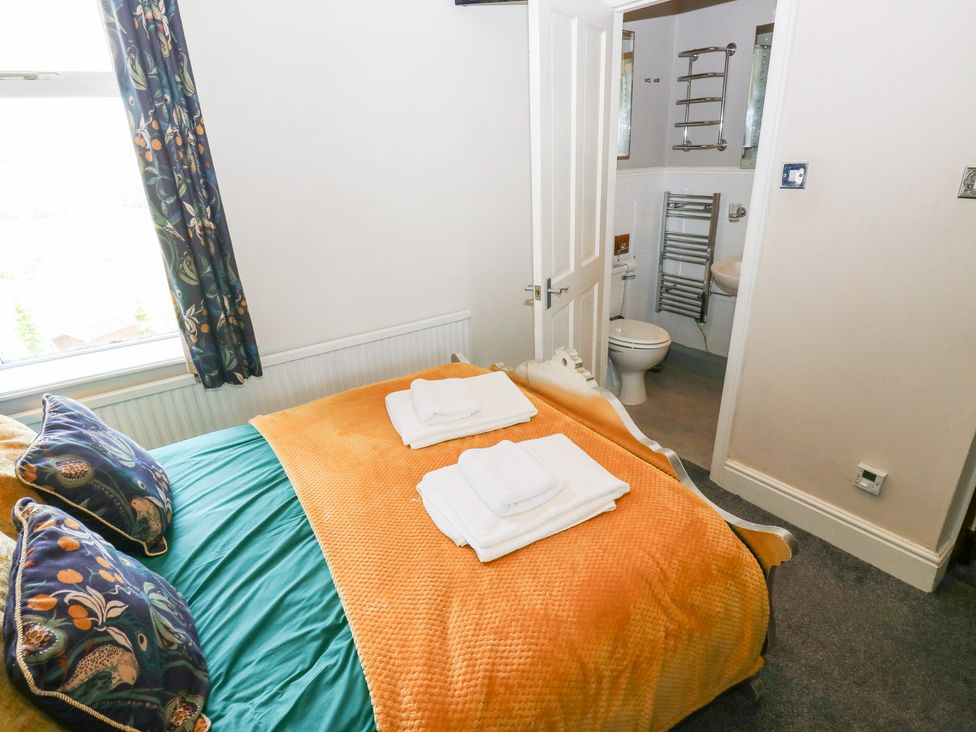 A bedroom with a bed and bathroom access at The Thyme House in Haworth