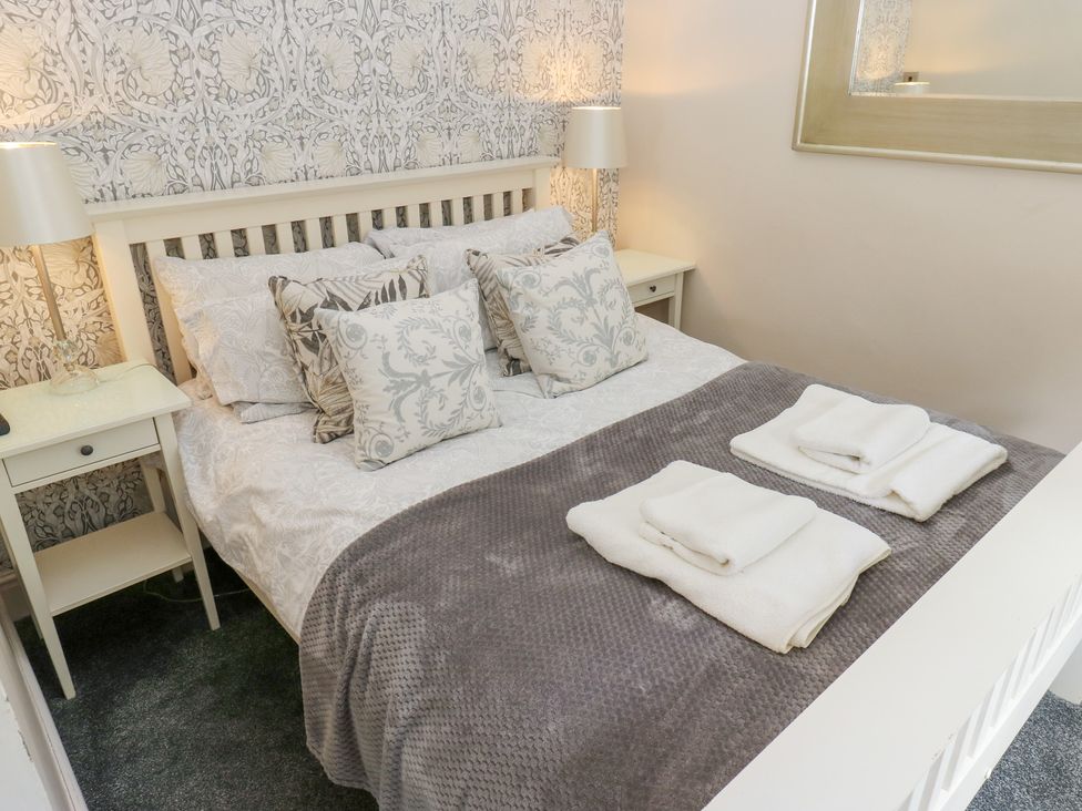 A bedroom with a bed, lamps, and towels at The Thyme House in Haworth