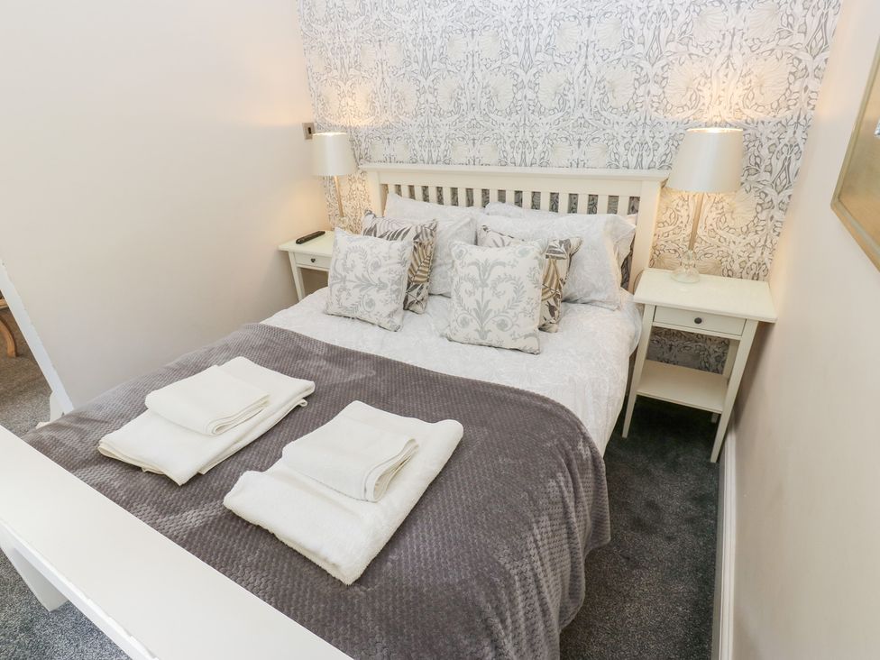 A bedroom with a bed and bedside table at The Thyme House in Haworth