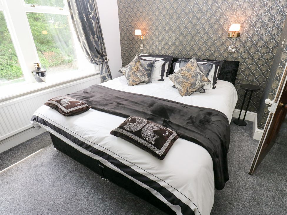 A bedroom with a bed and bedside table at The Thyme House in Haworth