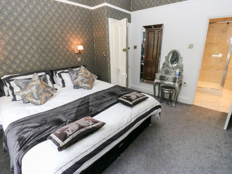 A bedroom featuring a bed with pillows and a dresser at The Thyme House in Haworth