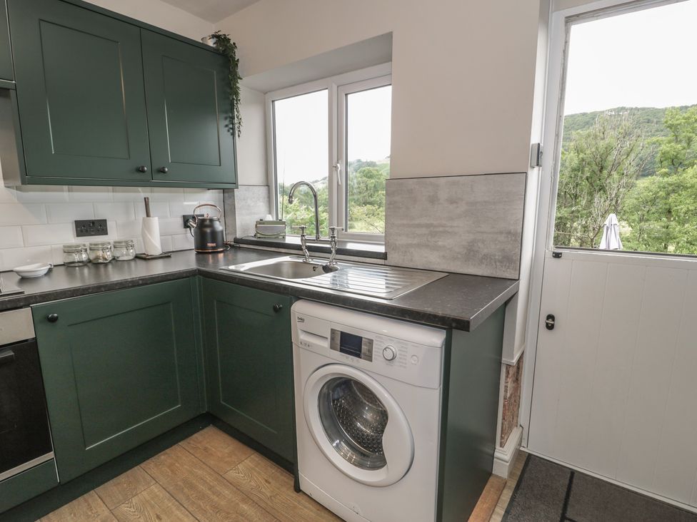 A kitchen with a washing machine and sink at Pengeulan in Cemmaes