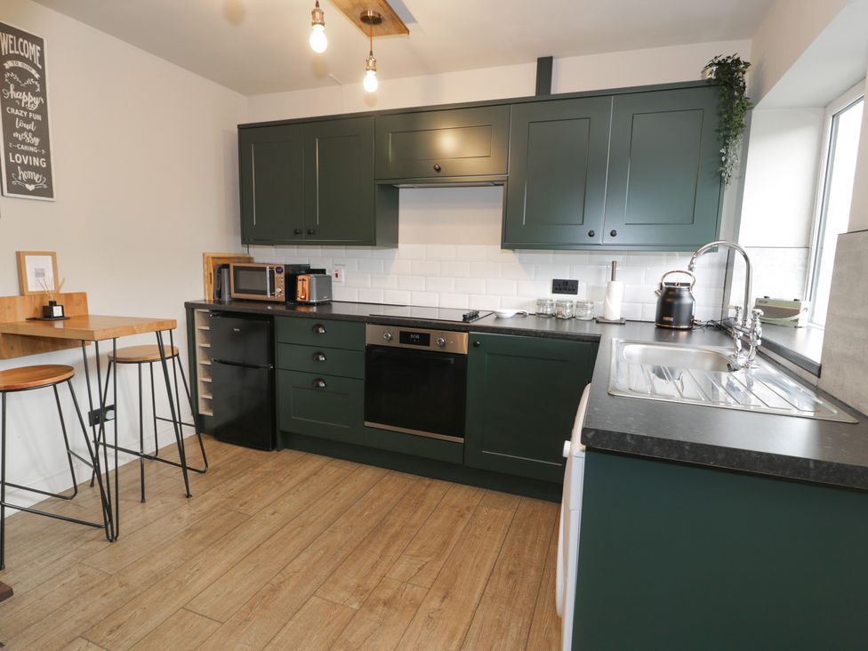 A kitchen with green cabinets and appliances at Pengeulan in Cemmaes