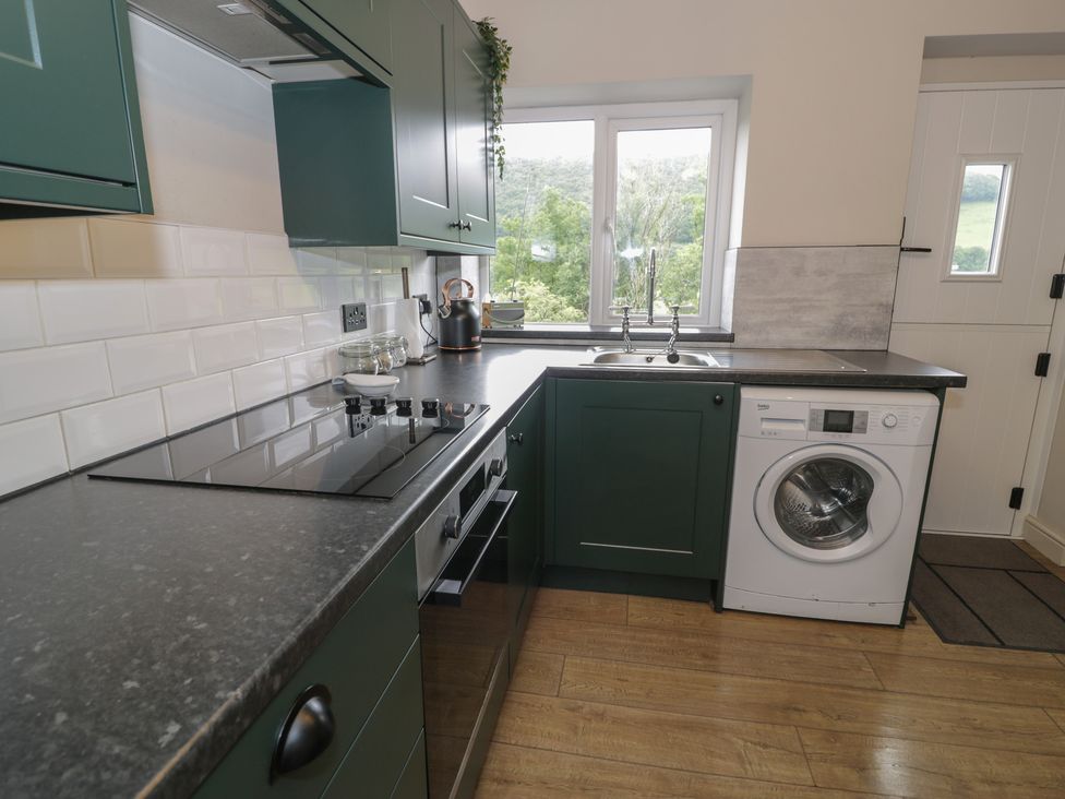 A kitchen with a washing machine and stove at Pengeulan in Cemmaes