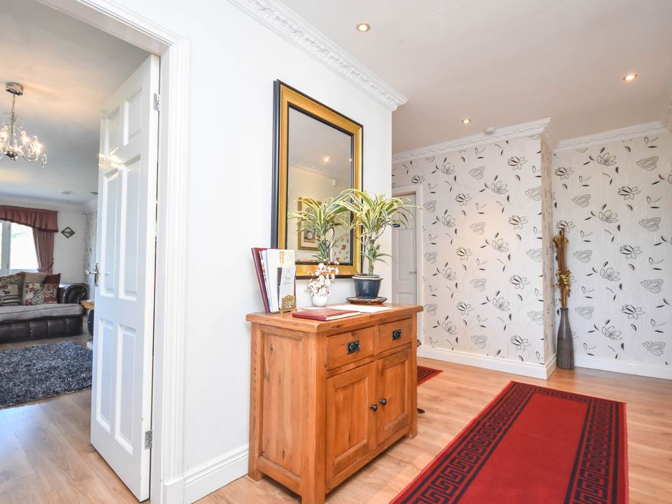 A hallway with a table and a mirror at Freshwinds in Market Drayton