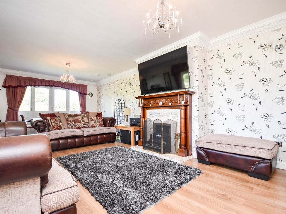 A living room with a sofa and a fireplace at Freshwinds in Market Drayton