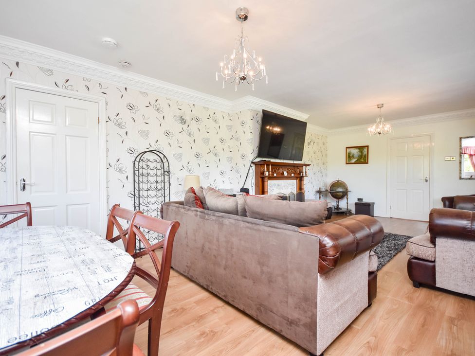 A living room with a sofa and dining table at Freshwinds in Market Drayton