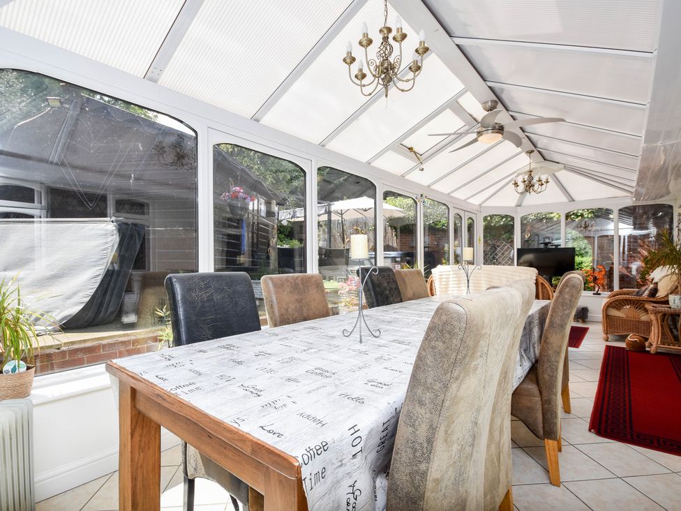 A conservatory with a table and chairs at Freshwinds in Market Drayton
