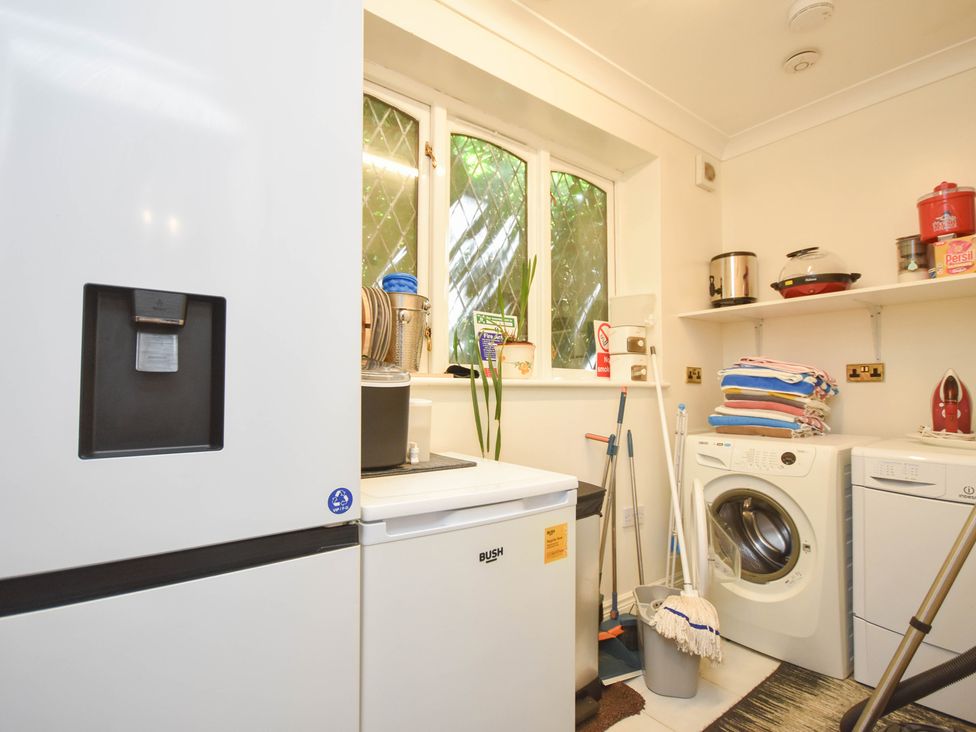 A laundry room with a washing machine and a refrigerator at Freshwinds in Market Drayton