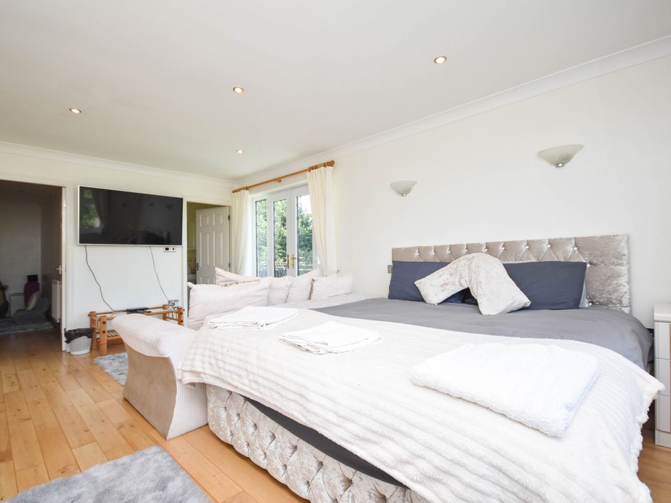 A bedroom with a large bed and television at Freshwinds Market Drayton
