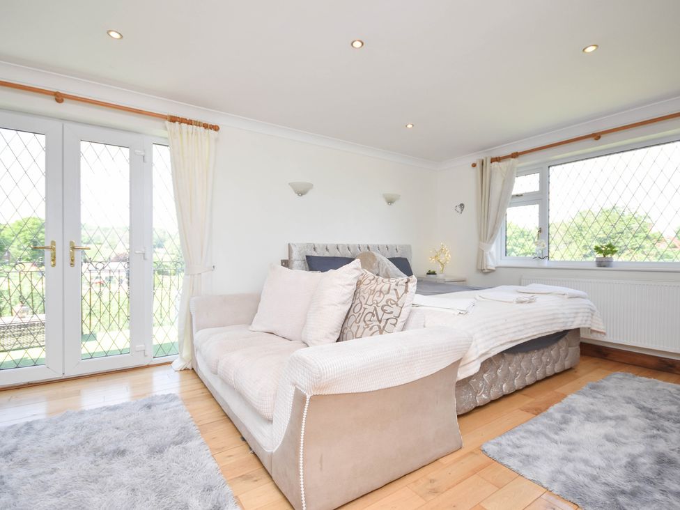 A bedroom with a bed and sofa at Freshwinds in Market Drayton
