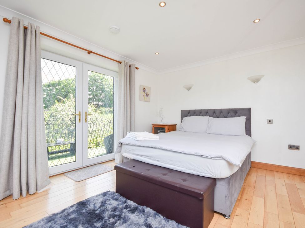 A bedroom with a bed and sliding door to the garden at Freshwinds in Market Drayton