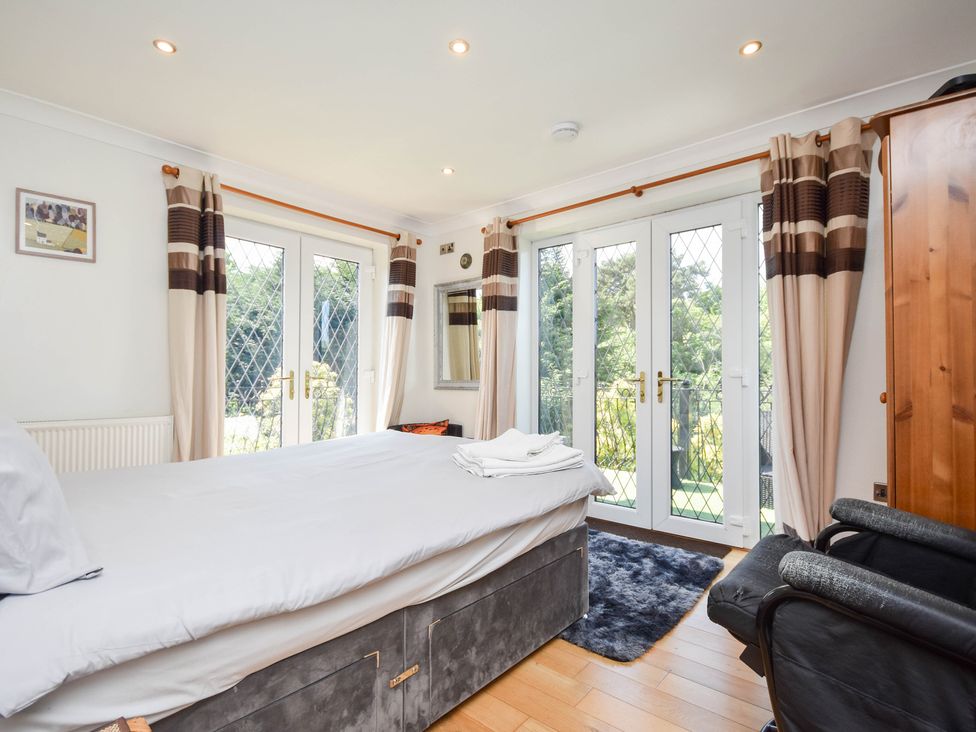 A bedroom with a bed and doors leading to outdoor space at Freshwinds in Market Drayton