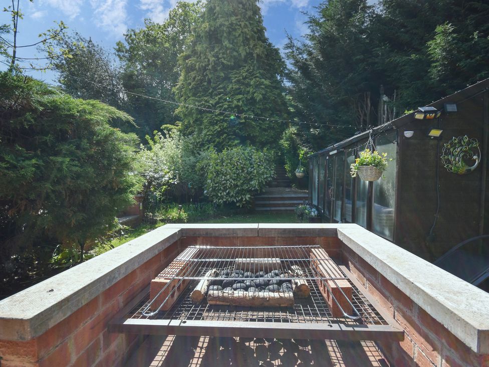 A barbecue grill with coals in a garden at Freshwinds Market Drayton