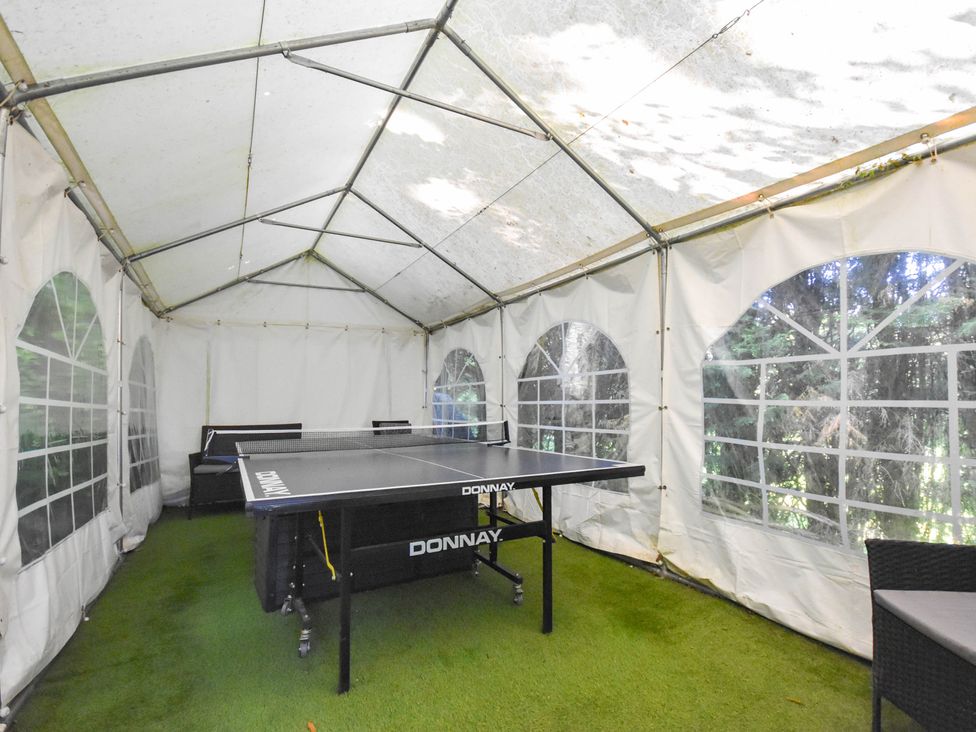 An outdoor structure with a ping pong table and seating at Freshwinds in Market Drayton