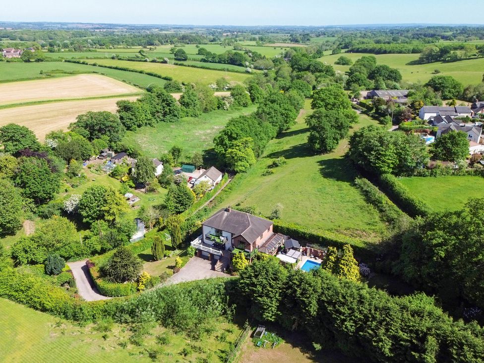 An aerial view of a house with garden and swimming pool at Freshwinds in Market Drayton