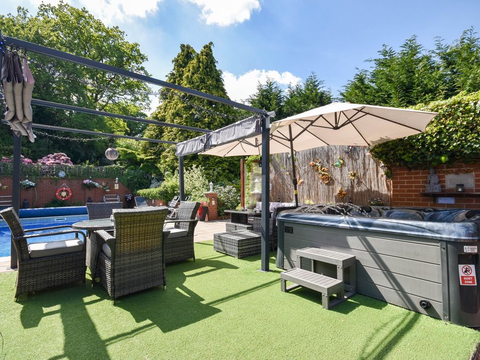 A garden with a swimming pool and hot tub at Freshwinds in Market Drayton