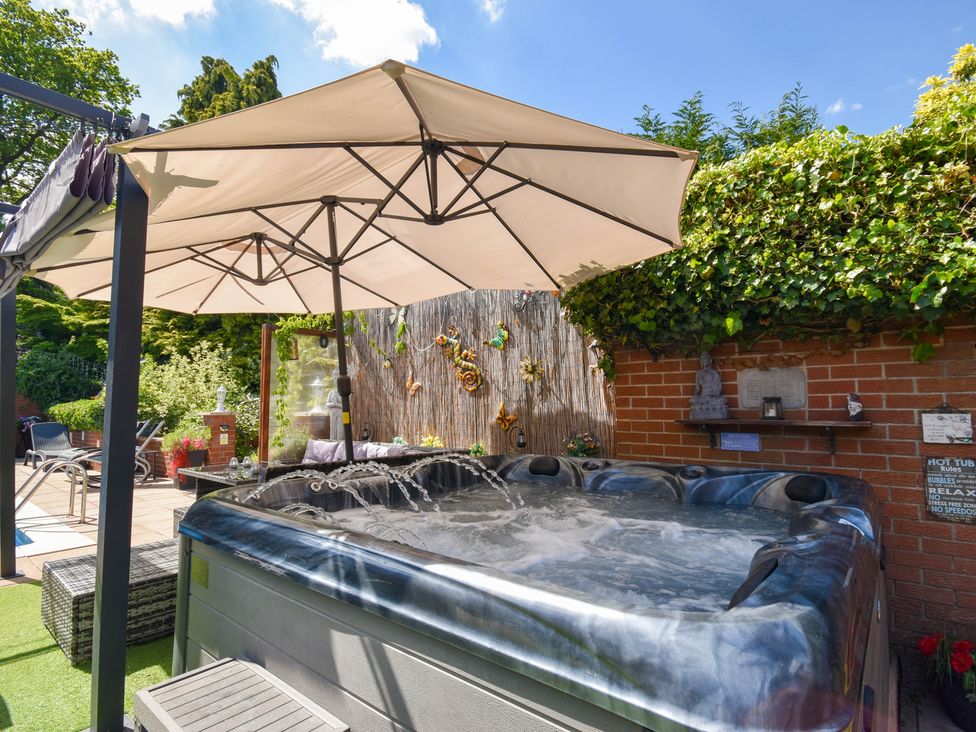 A garden with a hot tub and seating area at Freshwinds in Market Drayton