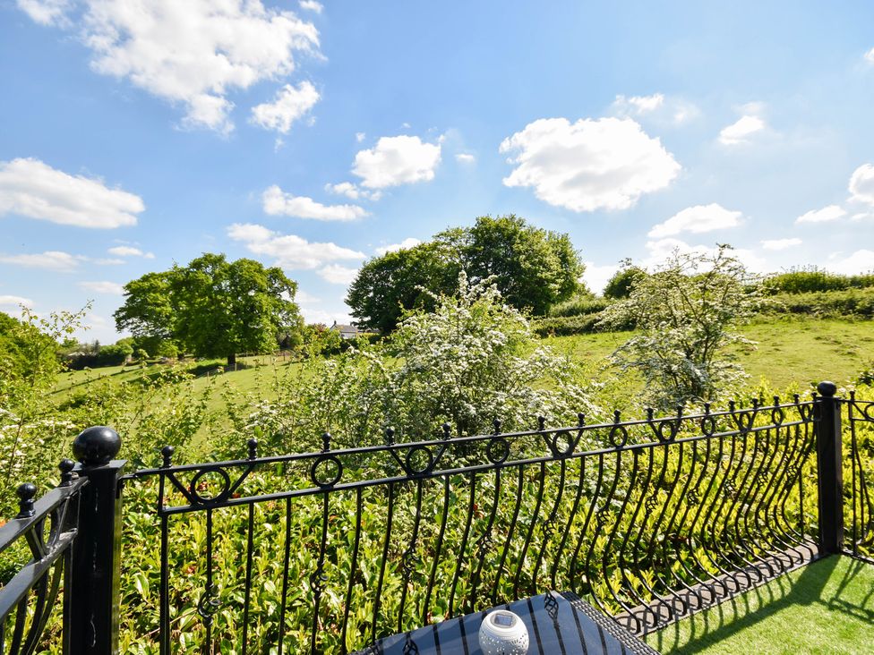 A view of a garden with a fence and trees at Freshwinds Market Drayton