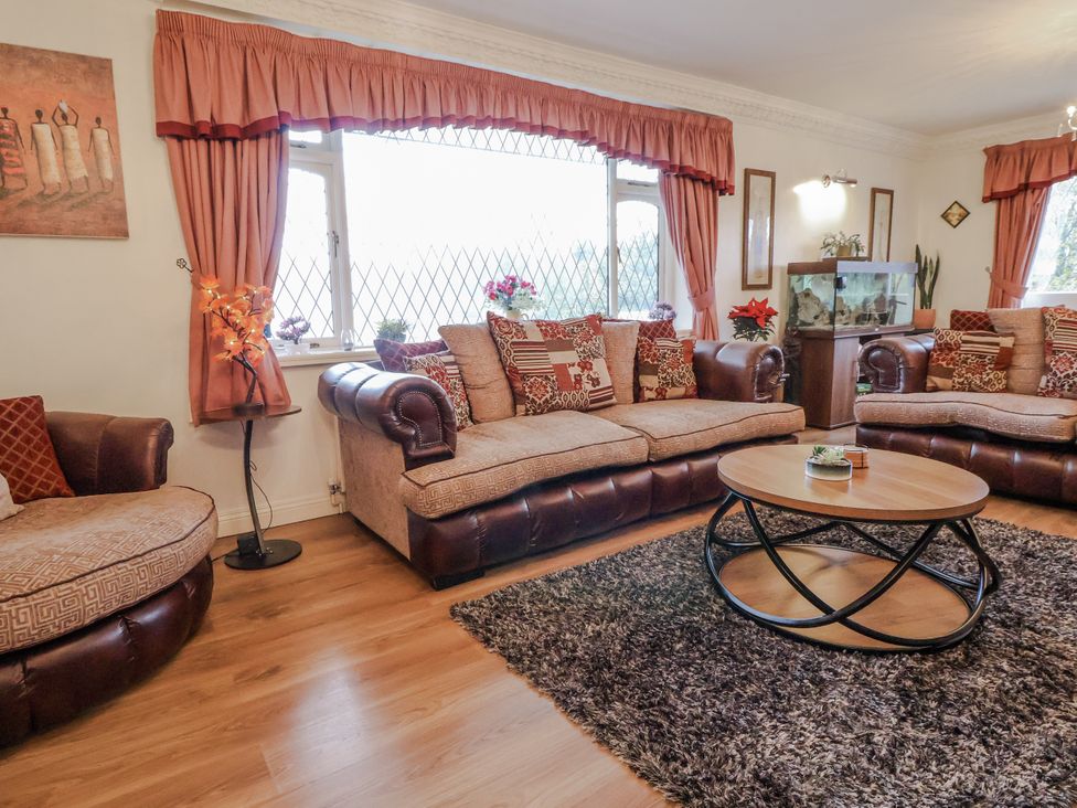 A living room with seating and a fish tank at Freshwinds in Market Drayton